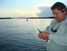Guide Capt. Randy DuMars prepares for fly fishing in the early morning. Sebastian Inlet Bridge in the background