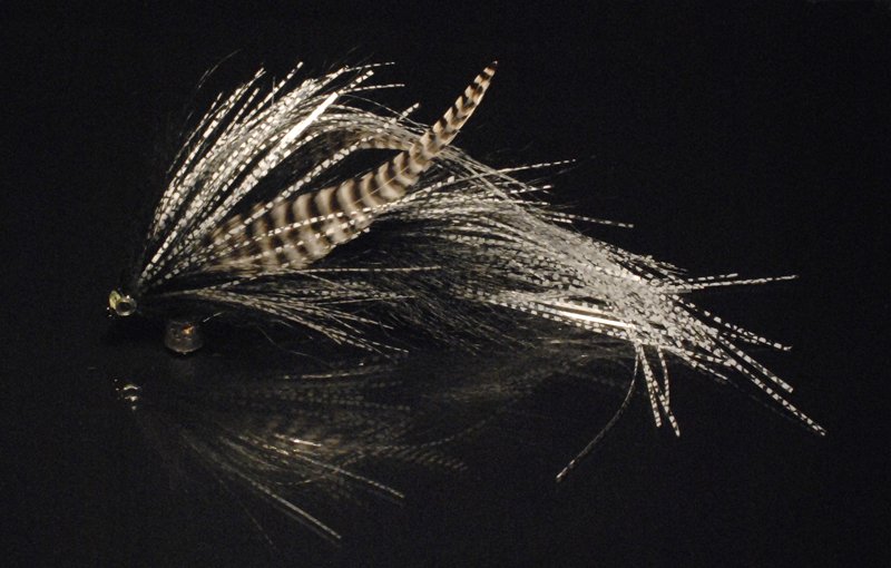 This one has been tied with black raccoon, white speckled Christmas tinsel, and grizzly microbarb saddles