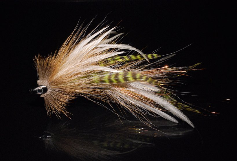 This one is a combination of tan bucktail chartreuse grizzly schlappen, white microbarb saddles and a tightly spun deer hair head crimped together with a fish skull