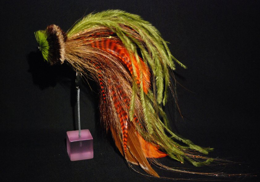 This one is a combination of orange and brown schlappen mixed with Olive ostrich herl and  tan bucktail. The head is a tightly packed spun deer hair head in tan dark brown and chartreuse
