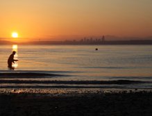Patrick Kent strips his fly as the sun rises over the Seattle skyline