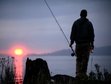 Ted McDermott watches the sun disappear while enjoying a cold one
