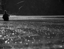 Black and White -- Nancy Harris casting on a perfectly flat day. As the tide moves in on days like this, it slowly picks up sand particles and keeps them on the surface of the water