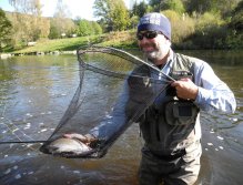 Large rainbow trout and happy angler